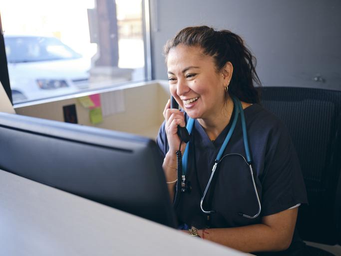 A healthcare working at a reception desk in an office.